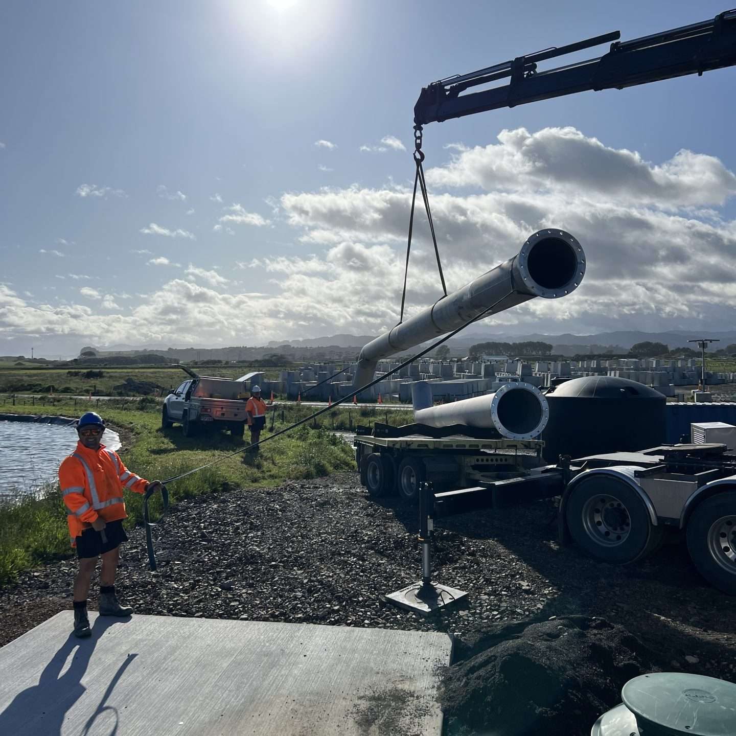 drain pipe being craned with a man watching